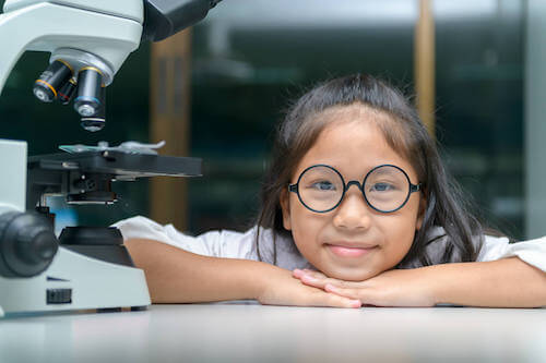 Bambina che ha appena usato un microscopio.