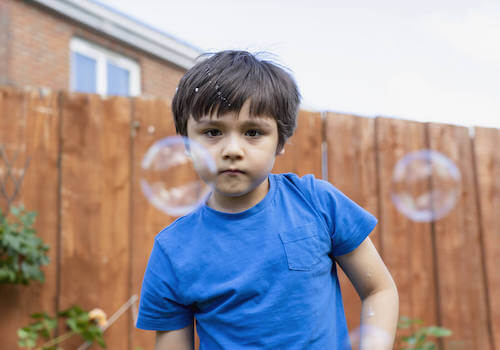 Bambino che si diverte giocando con le bolle di sapone.