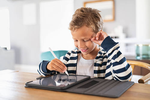 Bambino che studia utilizzando un tablet. Creare un'area studio.