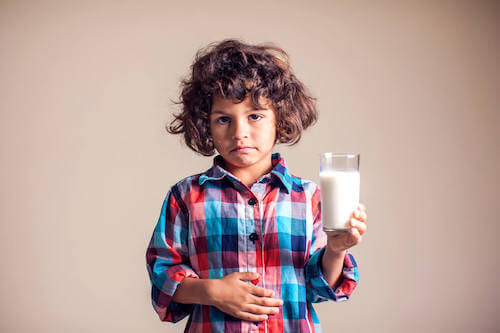 Bambino che ha dolore allo stomaco dopo aver bevuto del latte.