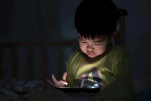 Bambino che usa il tablet di sera.