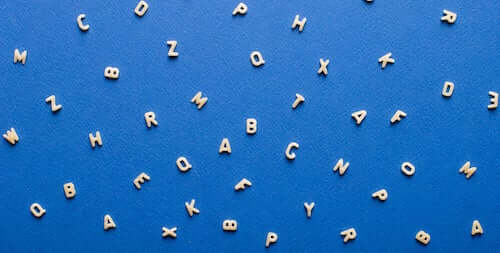 Lettere dell'alfabeto sparse su un foglio blu.