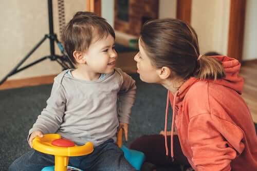 Madre che parla e gioca con il figlio piccolo.