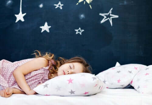 Bambina che dorme con parete di stelle.