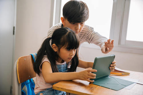 Bambini che usano un tablet per cercare informazioni su internet.
