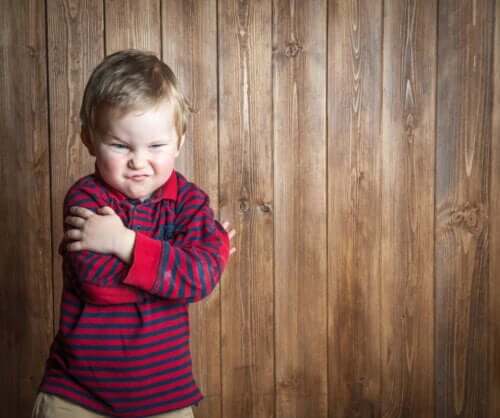 Bambino arrabbiato con maglietta a righe.