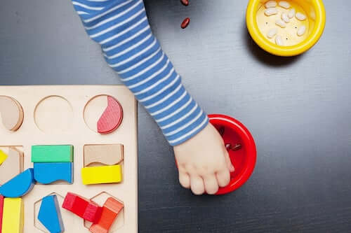 Bambino che gioca con le tavole Montessori.