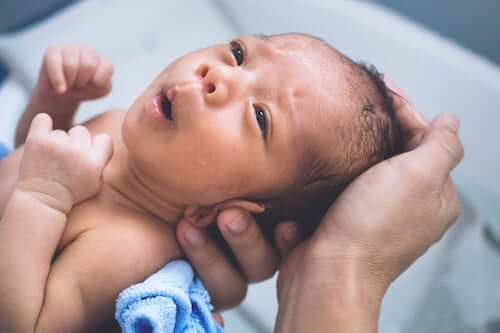 Padre che tiene in braccio il figlio neonato.