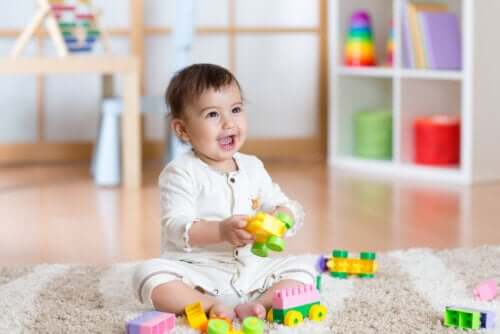 Giochi per le abilità motorie. Bambino con giocattoli sul tappeto.