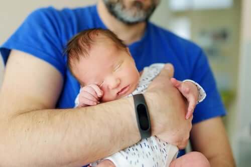 Papà che tiene in braccio il figlio appena nato.