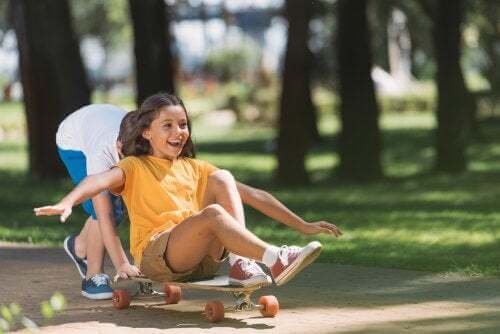 Bambini che giocano con una tavola da skate.