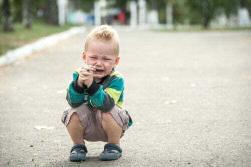 Bambino sensibile che piange in strada.