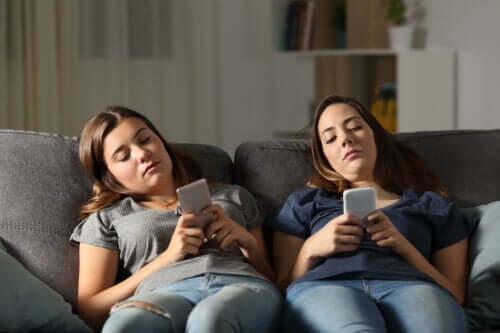 Adolescenti annoiati che guardano i loro telefoni cellulari senza fare i compiti.