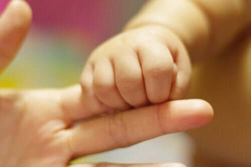 Gruppo di sostegno maternità: bambino stringe dito.