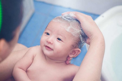 Lavare i capelli del neonato.