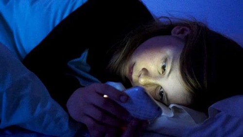 Bambina usa smartphone di notte.