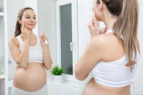 Donna in gravidanza allo specchio.